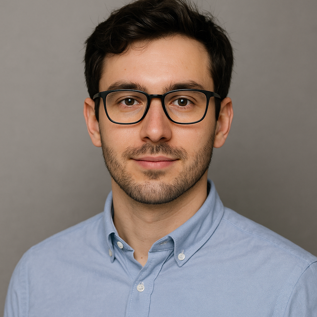 Professional headshot of a male AI and machine learning specialist wearing glasses and a blue shirt against a neutral background