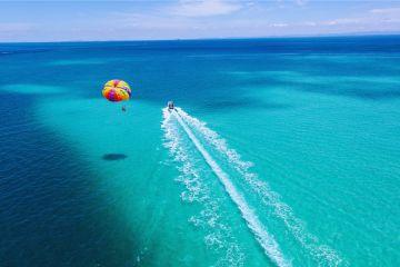 Parasailing above the turquoise waters of Ras Al Khaimah with a speedboat pulling the parachute