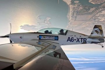 Extra 330 aerobatic aircraft flying upside down over Ras Al Khaimah coastline