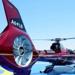 Helicopter Tour Abu Dhabi Helicopter flying over Abu Dhabi skyline with breathtaking aerial views of iconic landmarks and the coastline.