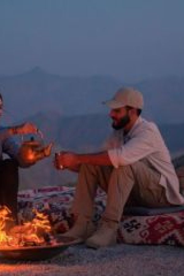 A couple sitting by a cozy campfire in Ras Al Khaimah