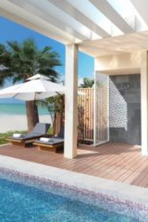 A private poolside villa with lounge chairs and ocean views in Ras Al Khaimah